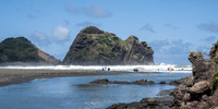 Surfers at Piha Beach with Nun Rock
