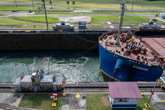 Cargo ship passing in the opposite direction at Gatun locks showing line handling trains